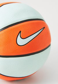 Nike basketball featuring a textured surface in orange and light blue, with black accents and a prominent white logo.