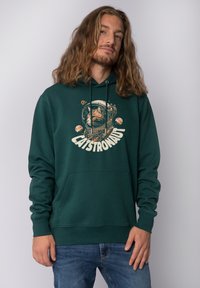 Donkergroene hoodie met een vooropstaand ontwerp van een kat in een astronautenhelm, met planeten en sterren. Het heeft een kangoeroezak en trekkoorden.
