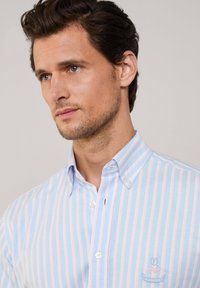 Maglietta a maniche corte a righe in blu chiaro e rosa, tessuto di cotone, colletto button-down, con logo ricamato sul petto, vestibilità classica.