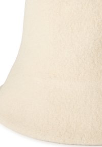 Kremowa tkanina o fakturowanej powierzchni z delikatnym wykończeniem i dzwonkowatym kształcie, odpowiednia do różnych zastosowań w dekoracji wnętrz.