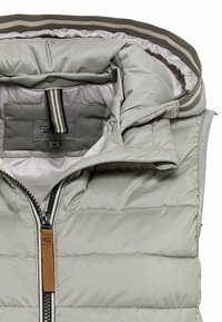 Lichtgrijze donzen bodywarmer met hoge kraag, volledige ritssluiting en bruin leren trekkoord. Voorzien van een gestreepte voering en een doorgestikte textuur.