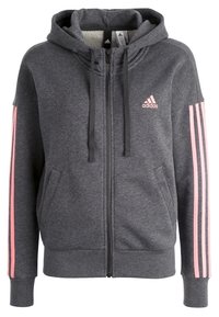 Sweat-shirt gris zippé en tissu doux, avec capuche, poches avant et accents roses à trois bandes sur les manches. Logo sur la poitrine.