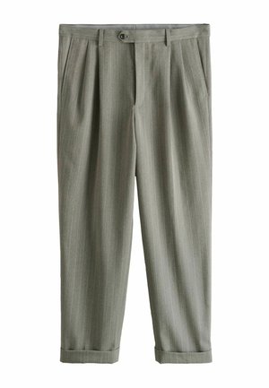 Mann trägt graue Nadelstreifenhose und weißes Hemd, zeigt die Gesäßtasche und die gesenkte rechte Hand.