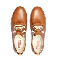 Scarpe in pelle marrone con finitura liscia, punta rotonda e lacci bianchi. L'interno presenta un leggero imbottitura e un marchio rosso.
