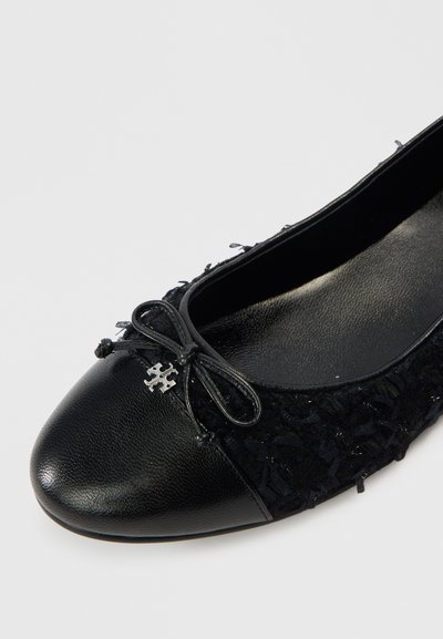 Μαύρο μπαλαρίνα με επάνω μέρος από υφασμάτινη υφή και λείο δερμάτινο κάλυμμα στα δάχτυλα. Διαθέτει φιόγκο με μεταλλική λεπτομέρεια λογότυπου στο μπροστινό μέρος.