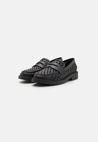 Svarte vevde loafers med flat såle, med en teksturert overdel og to frontremmer. Glatt syntetisk materiale med intrikate mønsterdetaljer.