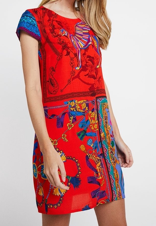 Röd klänning med korta ärmar med livfulla mönster, inklusive en kamel och blommönster, med en flödande passform och olika färgglada detaljer.
