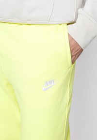 Nike Sportswear CLUB JGGR - Tracksuit bottoms - yellow strike