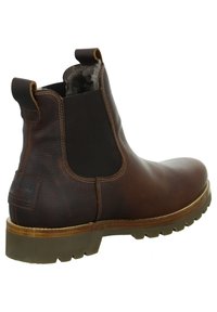 Stivale Chelsea in pelle marrone con pannelli elastici laterali, suola in gomma resistente e dettagli in cucitura; fodera in pelliccia visibile all'apertura.