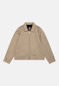 Beige zip-up jacket with a collared neck, two front pockets, and a patch logo. Made from smooth fabric with a relaxed fit and long sleeves.
