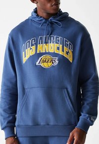 Sweat à capuche bleu marine en tissu doux, avec le logo "LOS ANGELES LAKERS" en jaune et blanc, capuche à cordon de serrage, et poche kangourou à l'avant.