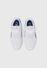 Baskets blanches avec un accent bleu, dotées d'une sangle en velcro, de lacets, d'un bout perforé et d'un logo doré sur la languette.