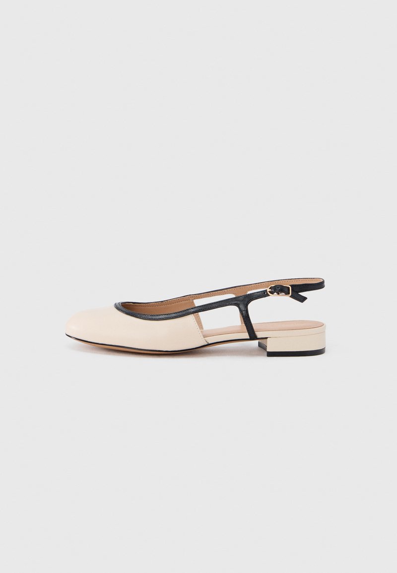 Chaussure à bride arrière en cuir avec un devant beige, un bord noir et un petit talon carré. Présente un dos ouvert et un design découpé.