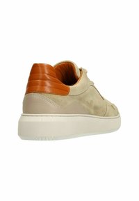 Beige suède sneakers met bruine leren accenten, gestructureerde hak, gewatteerde kraag en een witte rubberen zool met een geribbeld patroon.