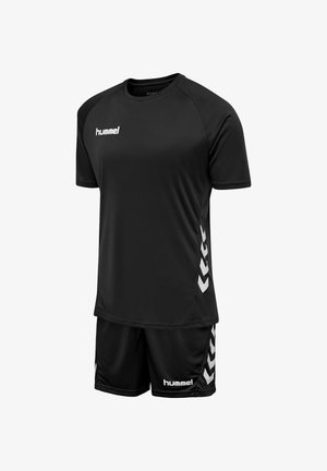 Sort sportsæt med korte ærmer og shorts, med hvide "hummel"-logoer og Chevron-mønstre på siderne.