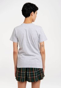 Gray cotton t-shirt with short sleeves, featuring a crew neck. Paired with a green plaid pleated skirt with red and yellow accents.