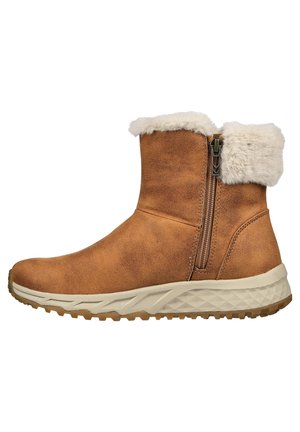 Bottines en suède marron avec un col en fausse fourrure blanche duveteux, fermeture éclair sur le côté et semelle en caoutchouc texturée beige et marron.