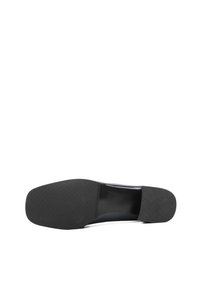 Semelle de chaussure noire pour homme avec grip texturé au talon et à l'avant-pied, vue de dessous sur fond blanc.