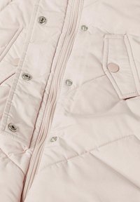 Lichtroze pufferjack met ritssluiting, drukknoopjes, gewatteerde textuur en twee voorkruiszakken met ronde knopen.