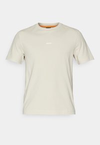 T-shirt en coton beige clair à manches courtes, décolleté rond, avec le logo "BOSS" blanc sur la poitrine. Texture simple et lisse.