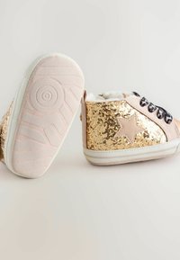 Stivali ankle in paillettes dorate con trim in suede rosa, lacci neri e rivestimento a fantasia; interno morbido e suola in gomma texturizzata.