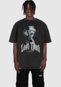 Fekete, túlméretezett póló, amelyen egy pénzt tartó kéz grafika és a "Lost Youth" felirat áll fehér színben, vintage, kopott hatású textúrával.