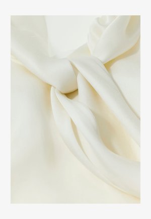 Tessuto liscio color crema raccolto e torcito per formare morbide pieghe e curve con una texture setosa.