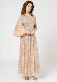 Robe nude à épaule unique avec des détails en perles métalliques et une manche froncée texturée. Tissu fluide avec des motifs de sequins, terminée par un ourlet long.