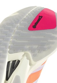 Η σόλα του παπουτσιού διαθέτει λευκή καουτσούκ βάση με υφή, σκούρες γκρι λεπτομέρειες και ένα έντονο ροζ τριγωνικό λογότυπο της Continental.