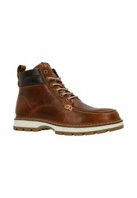 Botte en cuir brun avec un bout rond, semelle beige et quincaillerie argentée. Présente des accents cousus et un col rembourré pour un soutien optimal.