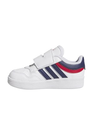 Baskets de sport blanches avec une bande Velcro, présentant des accents bleus et rouges ainsi que trois rayures marines sur le côté. Détails de la semelle texturée visibles.