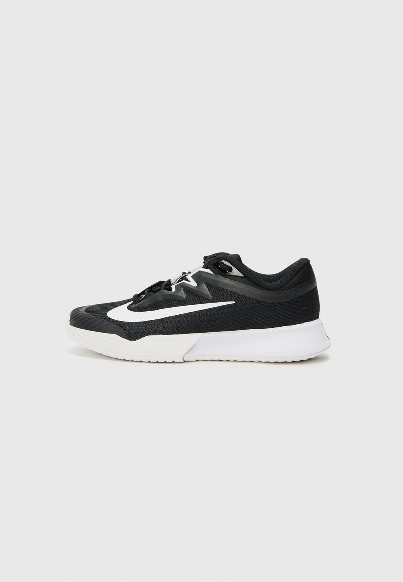 Black athletic shoe with white accents, featuring a textured upper, round toe, flat laces, and a thick white rubber sole.