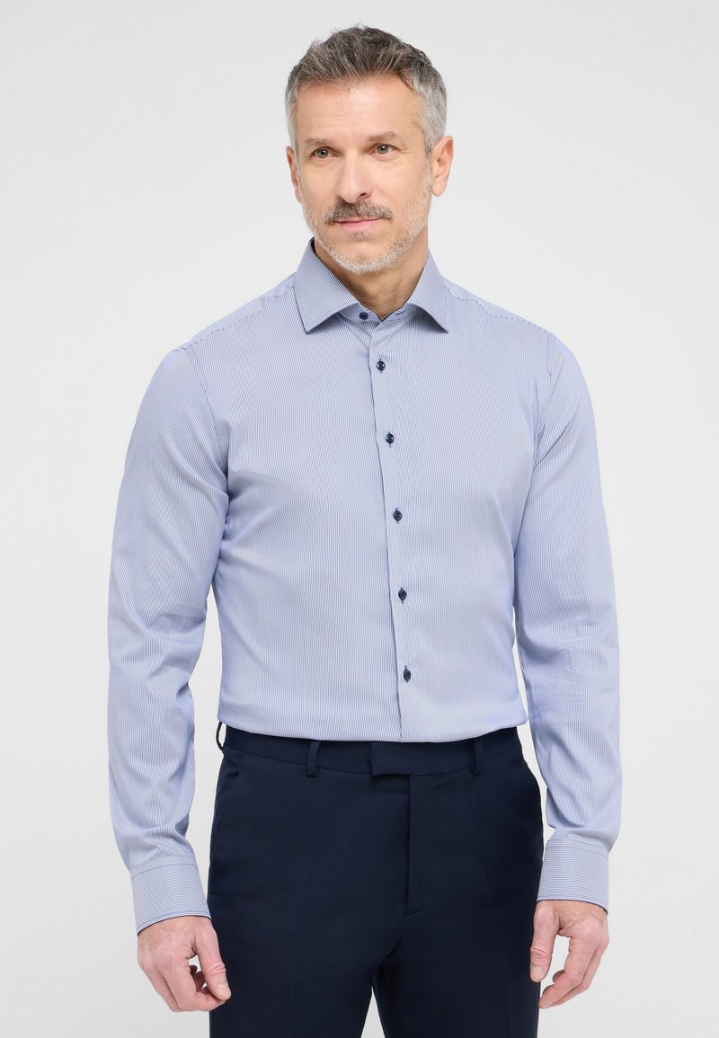 Camicia da uomo azzurro chiaro a maniche lunghe con sottili righe bianche, colletto con bottoni e bottoni a contrasto blu scuro. Tessuto morbido, vestibilità sagomata.