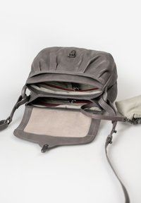 Borsa in pelle grigia con parte superiore arricciata, due scomparti e base in suede. L'interno presenta una fodera a righe e una chiusura magnetica.