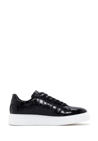 Baskets basses noires avec texture crocodile brillante et semelle blanche épaisse, montrées de profil côté droit sur fond blanc.