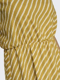 Geltona suknelė su zigzagų raštu baltos spalvos. Pagaminta iš minkštos medžiagos, su surinkta juosmeniu ir klostėmis.