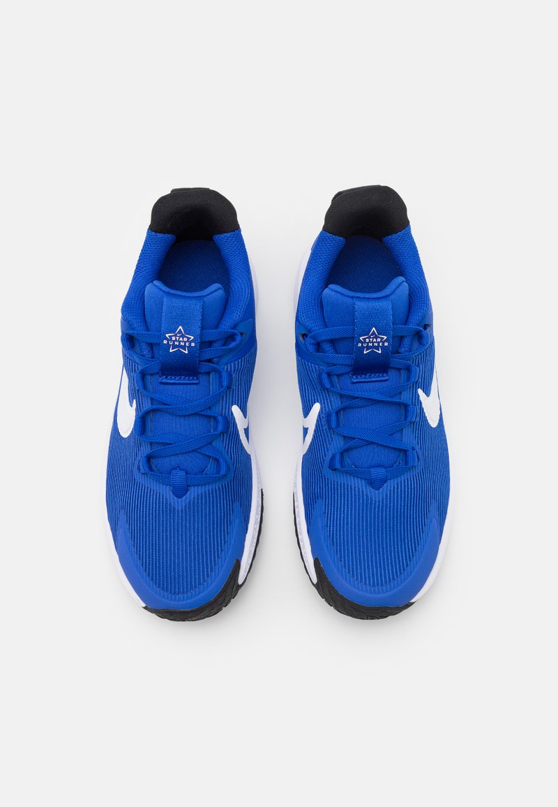 Scarpe sportive blu con tomaia in tessuto testurizzato, colletto imbottito nero, accentuazioni bianche a forma di swoosh e suola in gomma nera e bianca.