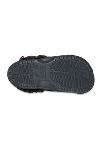 Black rubber sole with textured tread patterns, designed for traction. Features a fluffy upper material for comfort.