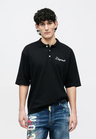 Mustast polo-särgist, millel on vaba lõige, kolme nupuga käisekinnituse ja vasakul rinnal valge tikitud logoga. Kandmisega sinised kulunud teksad.