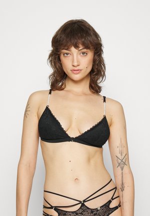 Zwarte kanten bralette met een driehoekig cupontwerp, gegolfde randen en parelaccenten op de bandjes; minimale hardware aan de voorkant.