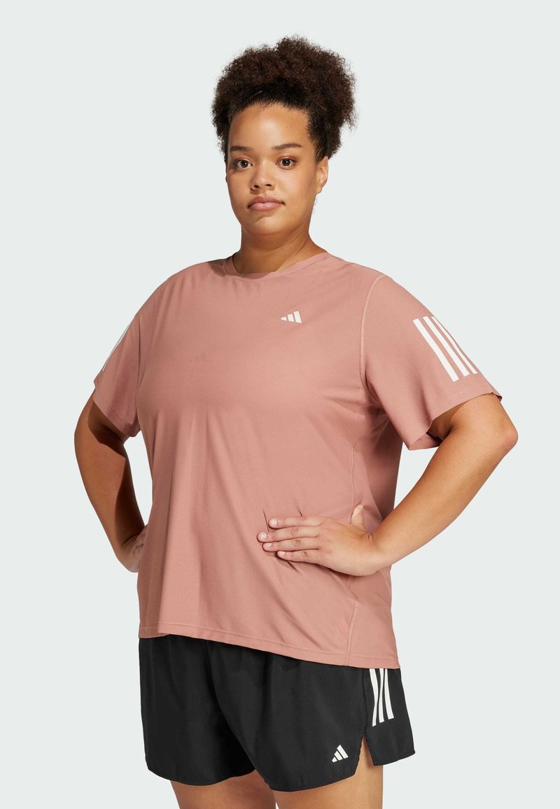 Maglietta sportiva rosa con collo a giro, maniche corte e dettagli bianchi sulla spalla sinistra, abbinata a pantaloni corti neri.