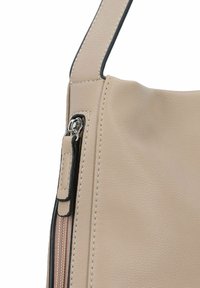 Beige leren handtas met een ritsluiting, een scherpe textuur en contrasterende zwarte stiksels langs de randen en hengsel.
