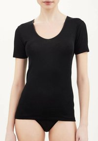 T-shirt nero a maniche corte con scollo rotondo, realizzato in materiale morbido ed elasticizzato, caratterizzato da un design aderente che valorizza la forma del corpo.