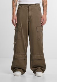 Brune cargo-bukser med en løs pasform, der har flere front- og sidelommer, lavet af robust stof og med detaljeret syning.