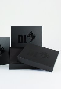 Black gift boxes with a matte finish, featuring a raised black logo of a horse and the letters "DL." Various sizes displayed together.