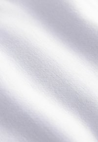 Weißer Stoff mit glatter, weicher Textur, versehen mit einem subtilen Webmuster, das in unterschiedlichem Licht einen leichten Glanz erzeugt.