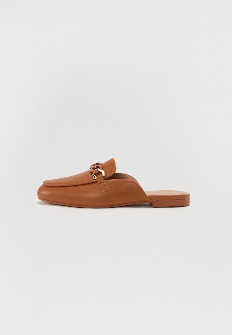 Mocassin en cuir marron avec détail en chaîne dorée et talon plat bas, présenté de côté sur fond blanc.