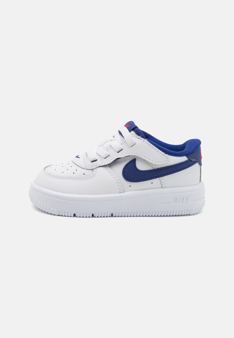 Nike Air Force 1 sneakers in white leather with blue accents, round toe, perforated details, and a textured white rubber sole.