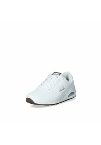 Sneaker sportivo bianco con tomaia sintetica liscia, chiusura con lacci, collo imbottito e suola in gomma marrone. Presenta un dettaglio del logo dorato.