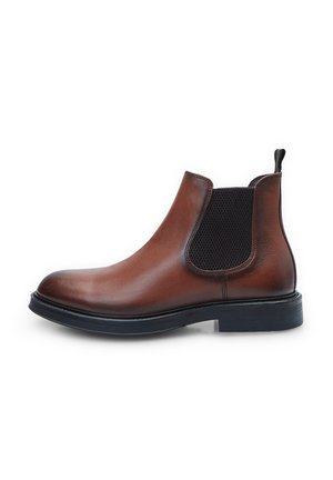 Bottines Chelsea en cuir marron avec panneaux latéraux élastiques, bout rond et semelle en caoutchouc durable. Présente une languette en tissu à l'arrière.